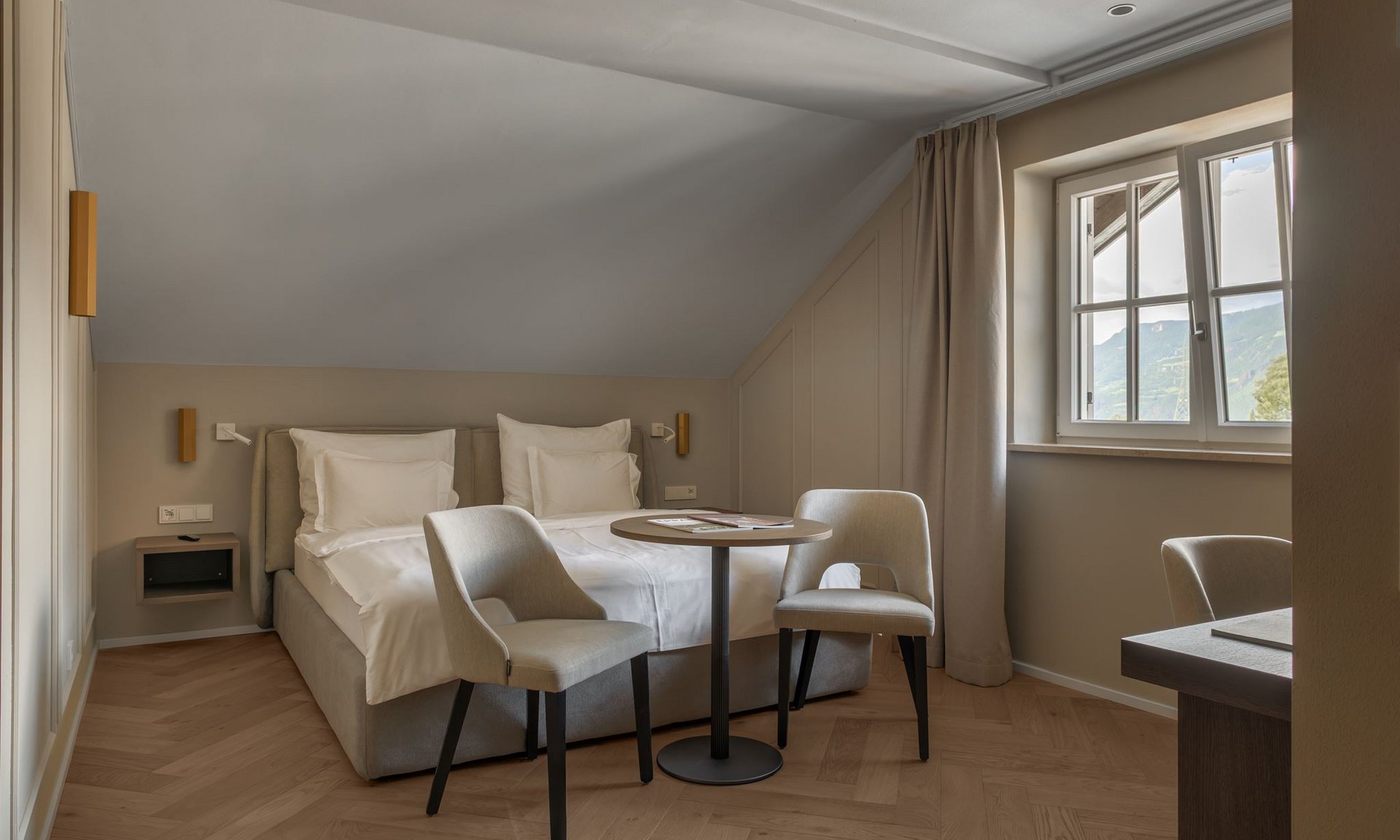 Gli scatti più belli del Lingers Camera d'hotel luminosa con letto matrimoniale, due sedie e tavolo vicino alla finestra
