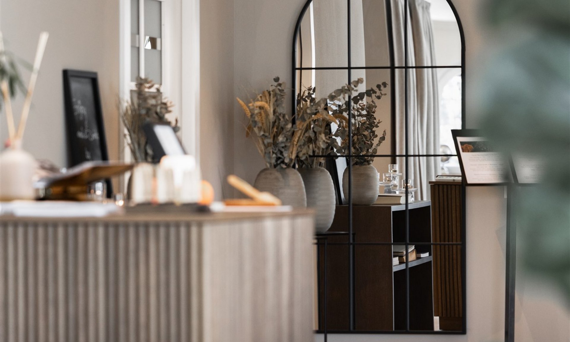 Stanza moderna con grande specchio da parete e vasi sul comò