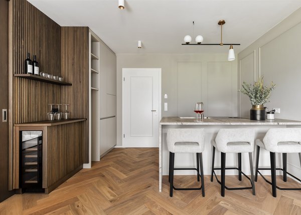 Apartment I Moderner Küchenbereich mit Barhockern, Weinkühler und Holzverkleidung