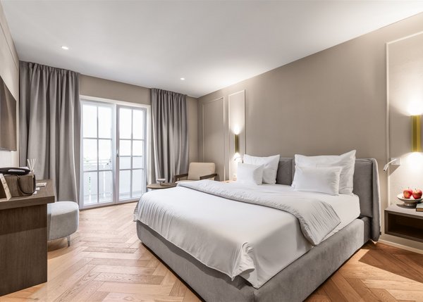 Lingers Junior Suites Modernes Hotelzimmer mit großem Bett, Fernseher und Balkon