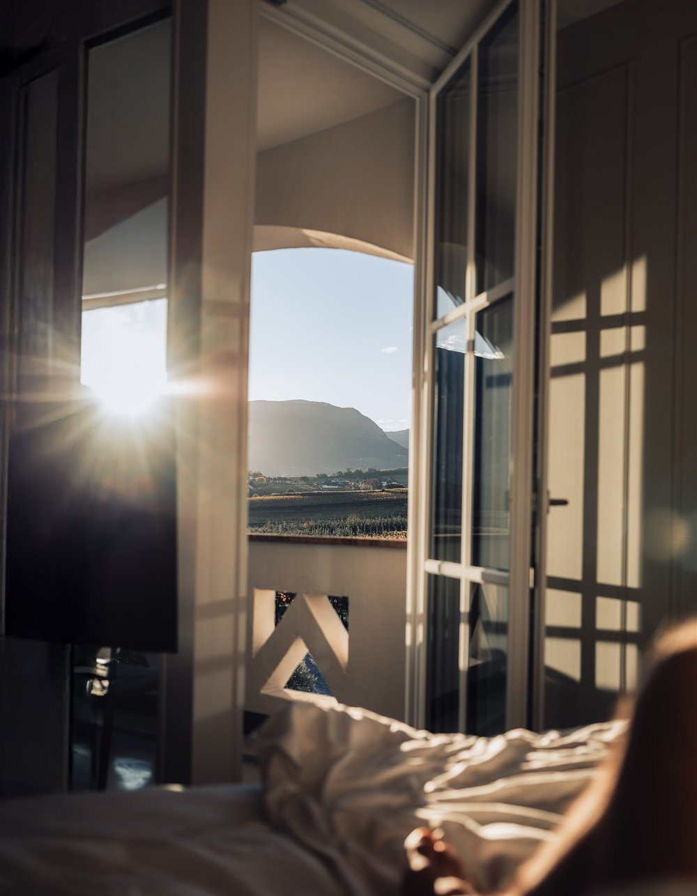 Sonnenaufgang auf einem Balkon mit Bergblick vom Bett aus