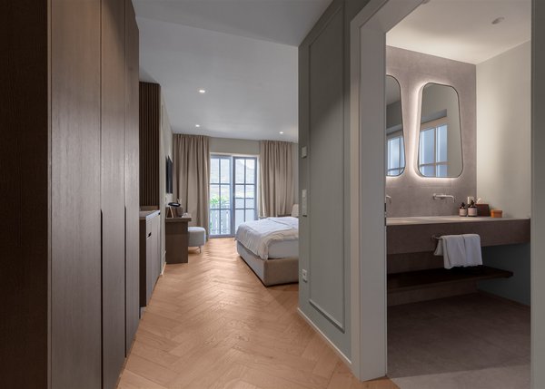 Lingers Junior Suites Moderner Hotelzimmerblick mit Bad links und Bett vor Fenster mit Vorhängen