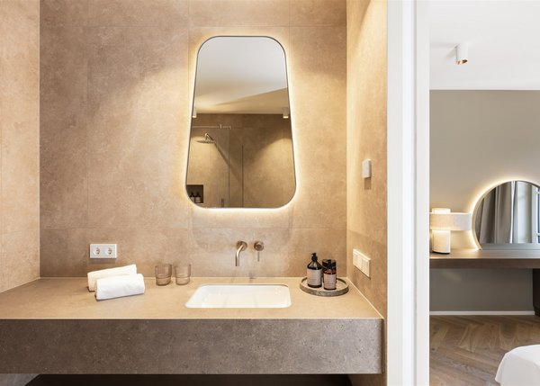 Apartment I Modernes Badezimmer mit beleuchtetem Spiegel und Waschtisch aus Stein