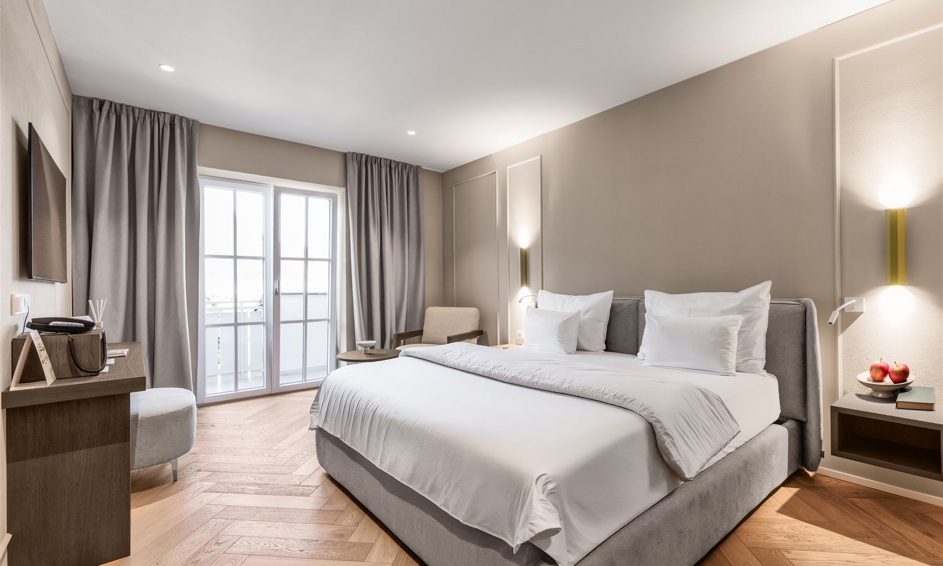 Camera d'albergo luminosa con letto matrimoniale e balcone