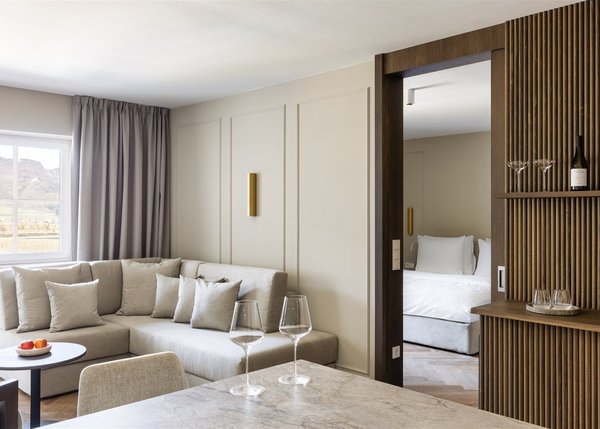 Apartment I Helles Wohnzimmer mit beiger Couch und Blick ins Schlafzimmer